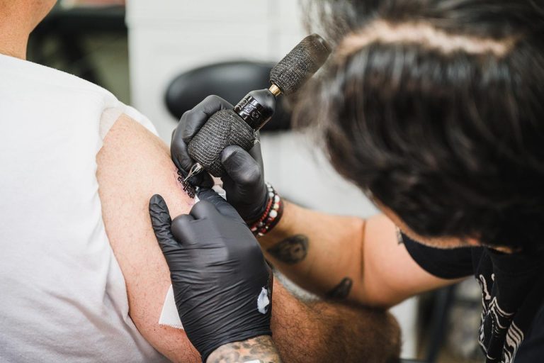 Home Vrouw brengt zachte tattoo crème voor gevoelige huid aan op verse tatoeage voor optimale verzorging